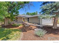 Charming home with a well-maintained yard, mature trees, and a cozy outdoor seating area with fire pit at 7261 Mount Meeker Rd, Longmont, CO 80503