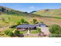 Single story home with a spacious yard, outdoor deck, and detached two-car garage at 1125 Stone Canyon Rd, Longmont, CO 80503