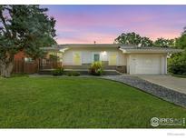 Charming single-story home with a well-maintained lawn and inviting curb appeal at dusk at 1202 9Th Ave, Longmont, CO 80501