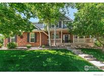 Charming two-story brick home featuring a well-manicured lawn and inviting front porch at 13951 Brookside Ct, Broomfield, CO 80023