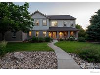 Charming two-story home with landscaped yard, stone accents, and inviting walkway at 14601 Akron St, Brighton, CO 80602