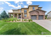 Beautiful two-story home featuring stone accents, a manicured lawn, and a three-car garage at 1485 Eversole Dr, Broomfield, CO 80023