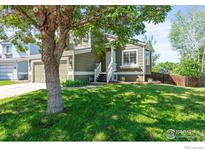 Inviting home featuring a well-manicured lawn and charming exterior with a cozy front porch and a welcoming entrance at 1595 Bain Dr, Erie, CO 80516