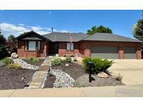 Charming brick home with an attached garage and a beautifully landscaped front yard at 1806 Crestone Ct, Longmont, CO 80504