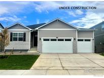 Charming single-Gathering home with two-car garage, gray siding, and well-manicured lawn at 1885 Mount Monroe Dr, Berthoud, CO 80513