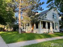 Charming two-story home with a well-manicured lawn and inviting front porch at 2204 Pine St, Boulder, CO 80302