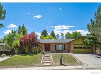 Charming single-story home with a brick facade, well-manicured lawn, and inviting curb appeal at 2513 Lanyon Dr, Longmont, CO 80503