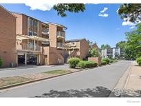 Brick condo building exterior with parking and landscaped grounds on a sunny day at 3009 Madison Ave # 317, Boulder, CO 80303