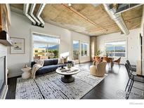 Open-concept living room with exposed ductwork, modern furnishings, and stunning mountain views at 3401 Arapahoe Ave # 420, Boulder, CO 80303