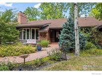 Charming home featuring a red tile roof, brick accents, and a beautifully landscaped front yard with a walkway at 4832 Silver Sage Ct, Boulder, CO 80301