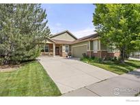 Charming home featuring a well-maintained lawn, long driveway, and inviting covered front porch at 6324 Saratoga Trl, Erie, CO 80516