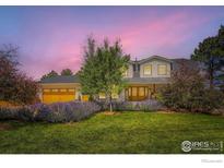 Inviting two-story home featuring a lush front lawn, colorful flowerbeds, and a charming double-door entrance at 6709 Walker Ct, Niwot, CO 80503