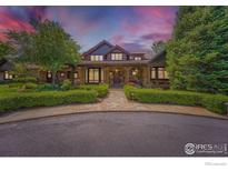 Charming stone and wood home featuring professional landscaping and inviting curb appeal at 8576 Niwot Meadow Farm Rd, Niwot, CO 80503