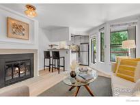 Bright living room with a fireplace, breakfast bar, and access to the outdoor balcony at 910 Portland Pl # 7, Boulder, CO 80304