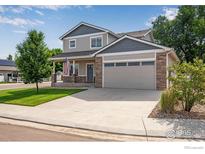 Charming two-story home features a stone-accented facade, attached two-car garage and manicured front lawn at 108 Wake St, Frederick, CO 80530