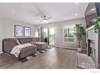 Spacious living room with modern flooring, stylish furniture, and natural light from a sliding glass door at 12183 W Chenango Dr, Morrison, CO 80465