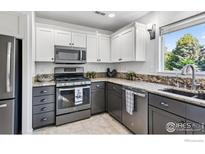 Modern kitchen featuring two-tone cabinets, stainless steel appliances, and granite countertops at 1993 S Fork Dr, Lafayette, CO 80026