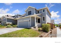Charming two-story home with a well-maintained lawn, attached garage, and inviting front porch at 2742 Cooperland Blvd, Berthoud, CO 80513