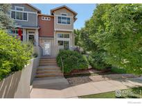 Beautiful townhome featuring steps to the front door and mature landscaping at 4108 Riley Dr, Longmont, CO 80503