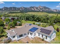Stunning mountain views enhance the rear of this beautiful home with solar panels and verdant landscaping at 4223 Eldorado Springs Dr, Boulder, CO 80303