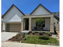 Charming home featuring a landscaped front yard, covered porch, and a two-car garage at 729 Kubat Ln # A, Longmont, CO 80503