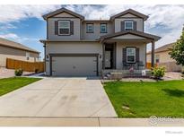 Two-story home featuring a neutral color palette, a two-car garage, and a well-maintained front yard at 7414 Blue River Ave, Frederick, CO 80530