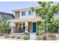 Charming two-story home featuring a welcoming front porch with nicely landscaped front yard at 8321 E 33Rd Ave, Denver, CO 80238