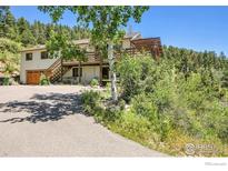 Charming home nestled in a mountain setting with an expansive deck and ample parking space at 13976 Wamblee Trl, Conifer, CO 80433