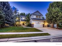 Charming two-story home featuring a well-manicured lawn, mature trees and a three car garage at 1405 Clover Creek Dr, Longmont, CO 80503