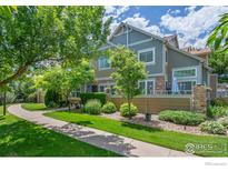 Charming exterior view of home with inviting walkway, stone accents, mature trees, and a well-maintained yard at 14300 Waterside Ln # E3, Broomfield, CO 80023