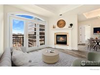 Elegant living room features a fireplace, balcony access, and views of the city skyline at 1827 N Grant St # 604, Denver, CO 80203
