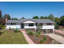 Charming ranch-style home featuring a well-maintained yard, tasteful landscaping, and a welcoming entrance with a pop of color at 2125 Rangeview Ln, Longmont, CO 80501