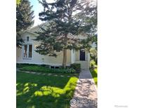 Charming home featuring a lush green lawn, mature trees, and a welcoming entryway and walkway at 2949 10Th St, Boulder, CO 80304