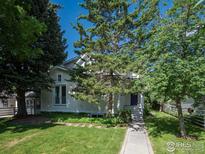 Charming home exterior with a lush front yard and mature trees on a sunny day at 2949 10Th St, Boulder, CO 80304