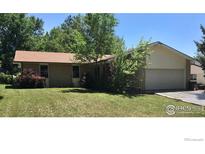 Charming single-story home featuring a brick facade, well-maintained lawn, and mature trees at 3814 Columbia Dr, Longmont, CO 80503