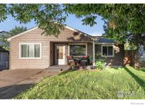 Charming single-story home features a cozy front porch and well-maintained lawn at 4240 Harlan St, Wheat Ridge, CO 80033