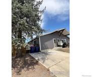 Charming single-story home with gray siding and a spacious driveway under a sunny blue sky at 601 5Th St, Frederick, CO 80530