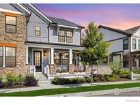 Charming two-story home with a welcoming front porch and beautifully landscaped front yard at 91 Westerly Blvd, Erie, CO 80516