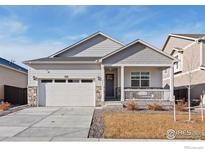 Charming single-story home with a welcoming front porch and attached two-car garage at 9873 Ceylon St, Commerce City, CO 80022