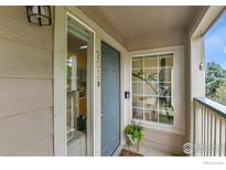 Inviting front entrance with a grey door and visible house number, well lit at 1050 Opal St # 203, Broomfield, CO 80020