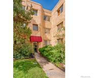 Charming brick apartment building with well-manicured lawn and a red awning over the entrance at 1100 Colorado Blvd # 305, Denver, CO 80206