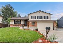 Charming two-story home featuring a well-manicured lawn, brick accents, and a welcoming front porch at 11064 Otis St, Westminster, CO 80020
