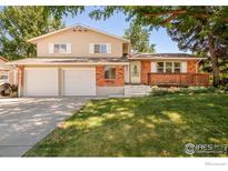 Inviting two-story home with a well-maintained lawn, two-car garage, and a cozy front porch at 1332 S Lincoln St, Longmont, CO 80501