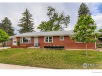 Charming single-story brick home with a well-maintained lawn and mature trees at 1345 Northwestern Rd, Longmont, CO 80503