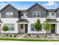 Charming townhome with white siding, dark trim, and well-maintained landscaping at 1776 Glacier Ave, Berthoud, CO 80513