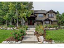Charming exterior of a two-story home with beautiful landscaping and a stone-lined walkway at 2121 Jade Way, Longmont, CO 80504