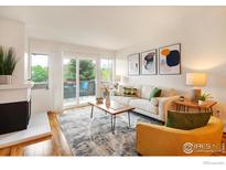 Bright living room with a cozy fireplace, stylish decor, and a sliding glass door to a balcony at 3240 Iris Ave # 201, Boulder, CO 80301