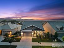 Charming home with a well-manicured lawn and a beautiful sunset in the background at 3315 Heron Lakes Pkwy, Berthoud, CO 80513