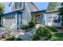 Charming home with blue trim, a well-maintained lawn, and a cozy front porch at 3598 Larkspur Dr, Longmont, CO 80503