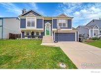 Inviting two-story home featuring blue siding, a bright green front door, and a well-maintained lawn at 360 Wellington Ave, Lafayette, CO 80026